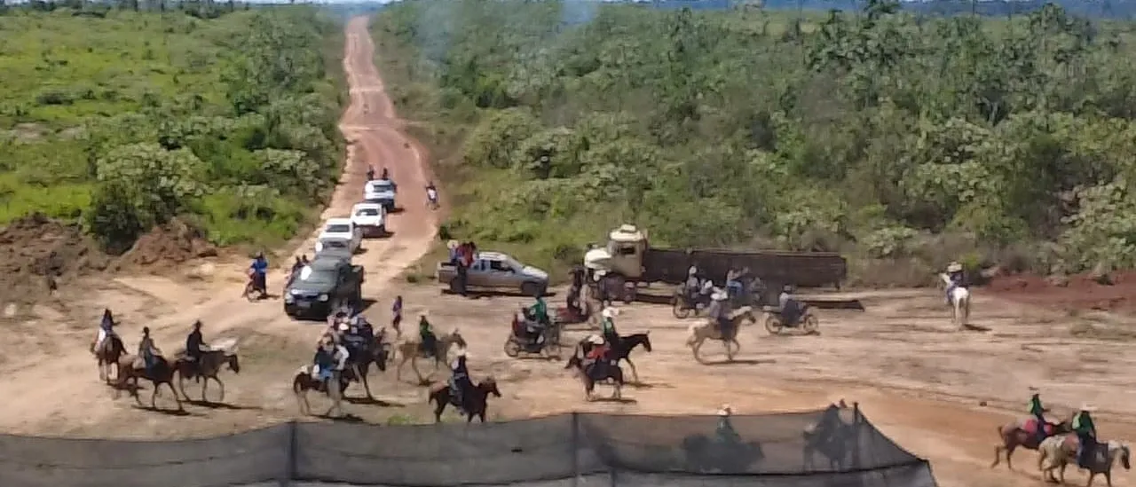 Dozens of people on horseback and pickup trucks gathered on a dirt road cut through the forest.